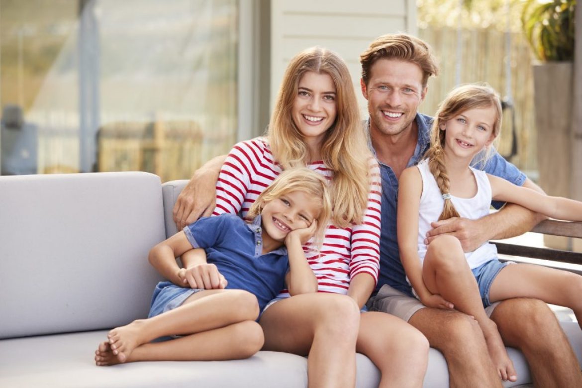 smiling family sitting on couch