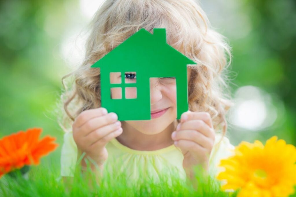 child looking through cut out of house