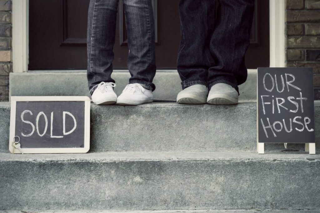couple sitting on steps of new house