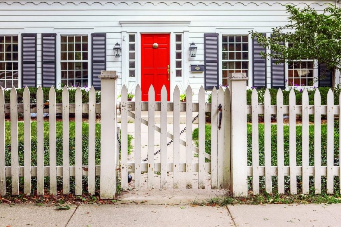 house with red door and fence in yard