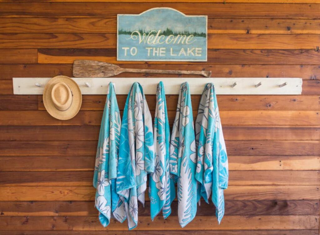 towels and hat hanging on towel rack at lake house